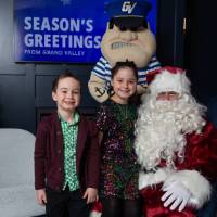 Brother and sister smile with Santa and Louie